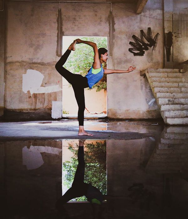 Woman performing a graceful yoga pose in a calm environment.